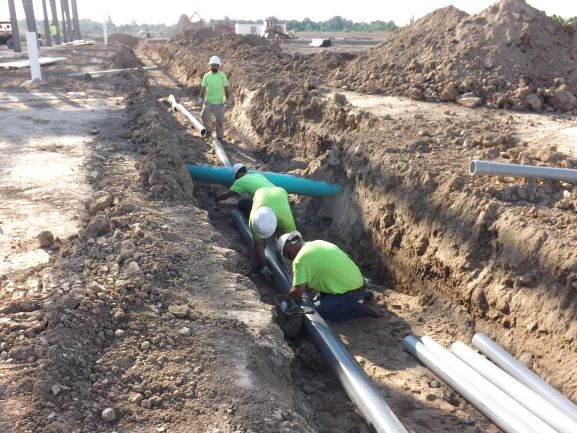 PIE&G crews laying conduit in trench for utilities