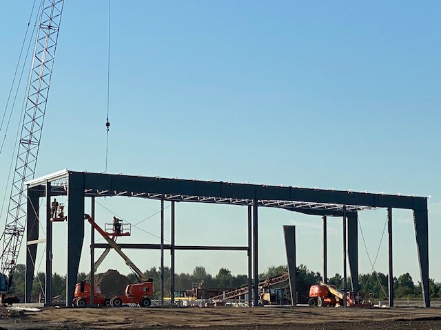 7-8-20 Workers on raised hydraulic platforms fasten steel grid at top of structural steel framework
